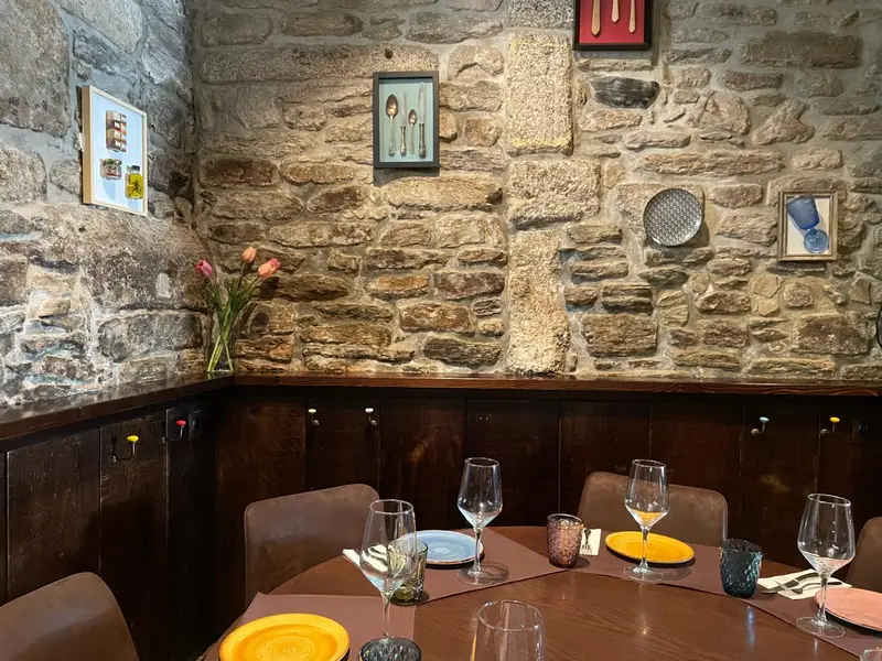 Muro de piedra rustica con mesa y vajilla de colores