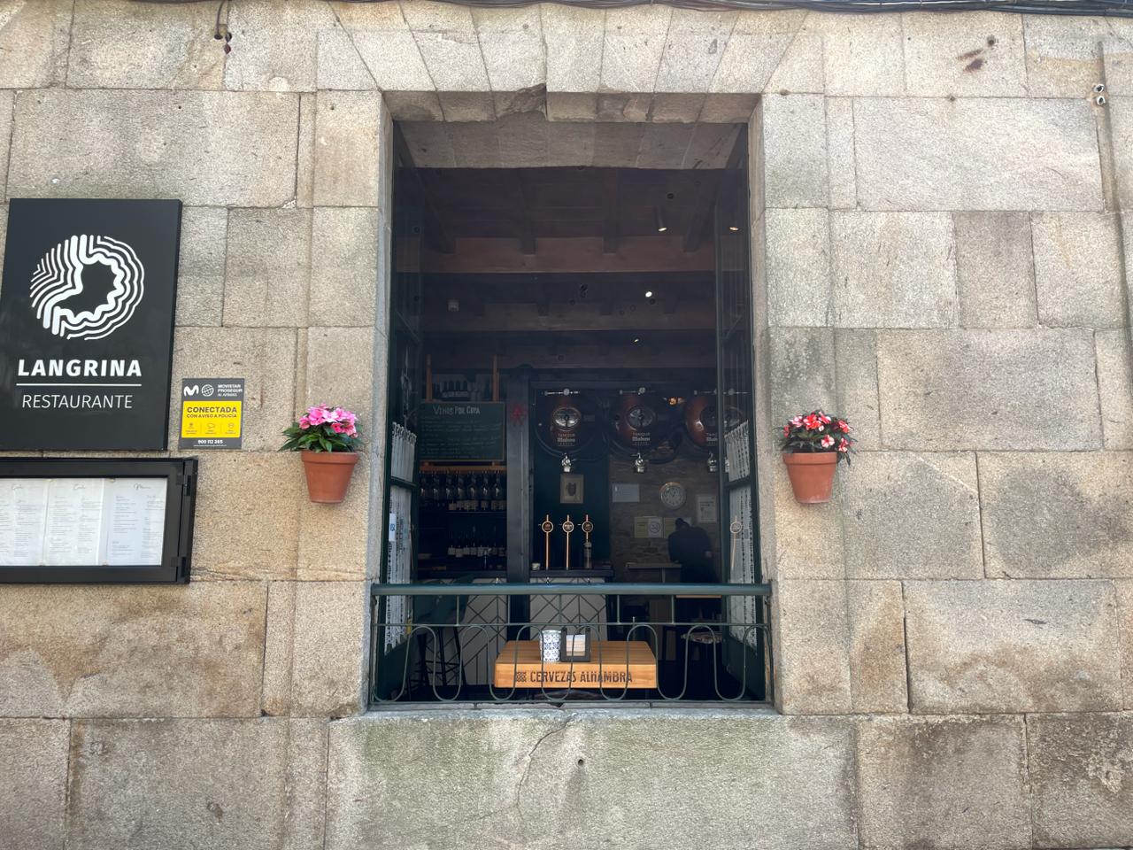 Ventana de la bodega de Langrina con vinos por copa y grifos de cerveza