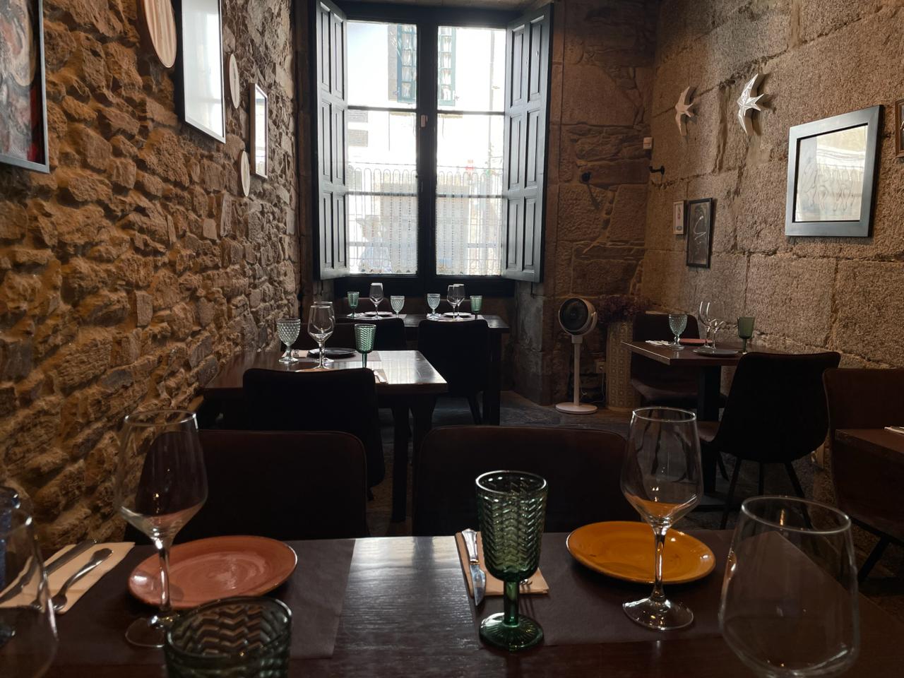 Sala de granito con mesas preparadas y copas de vino