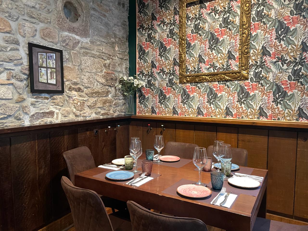 Comedor con papel pintado floral, marco dorado y mesa preparada
