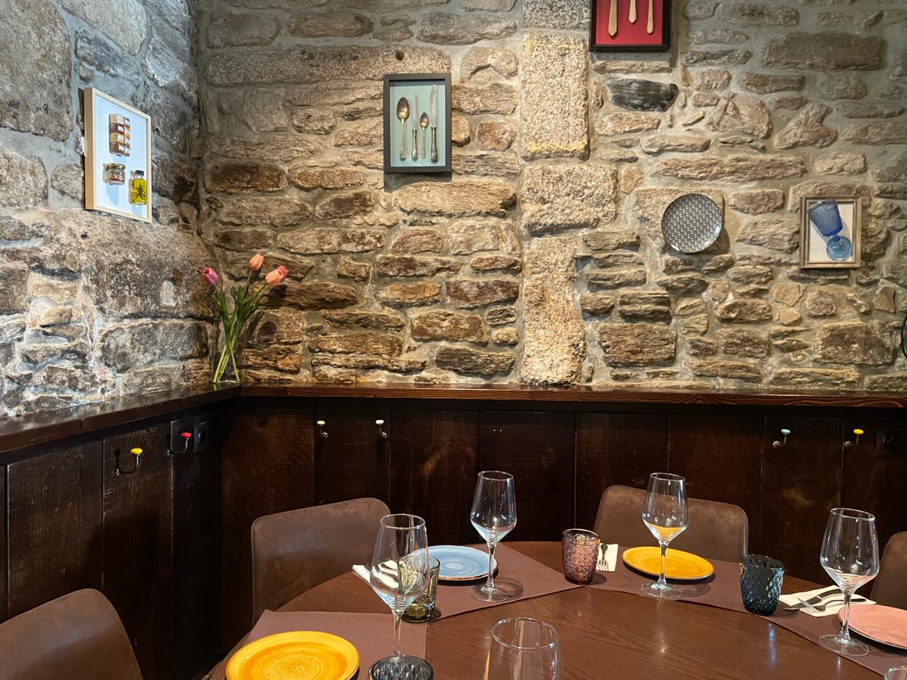 Muro de piedra rustica con mesa y vajilla de colores